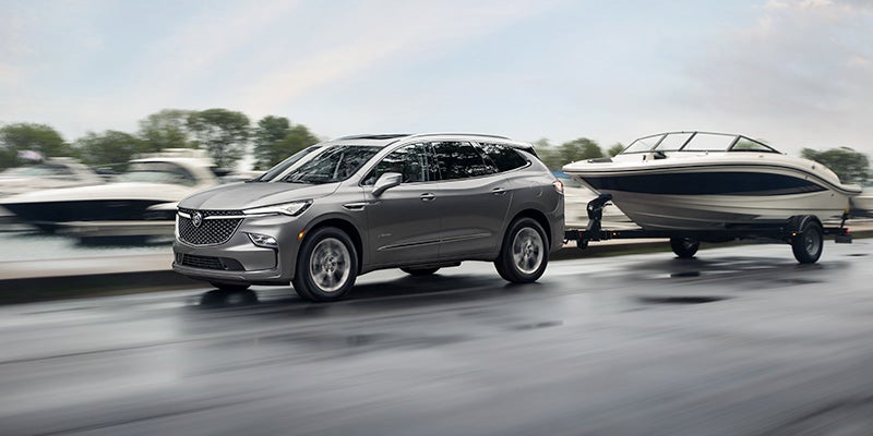 A silver Buick Enclave hauling a boat