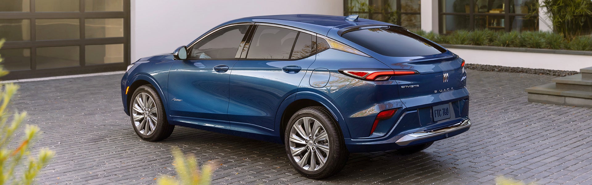 A blue Buick Envista, parked in a driveway.