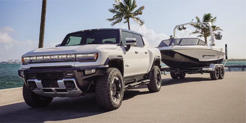 A whote, GMC Hummer EV hauls a boat