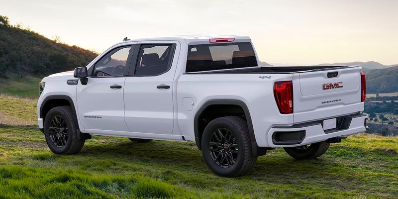 A white, GMC Sierra 1500 parked in grass
