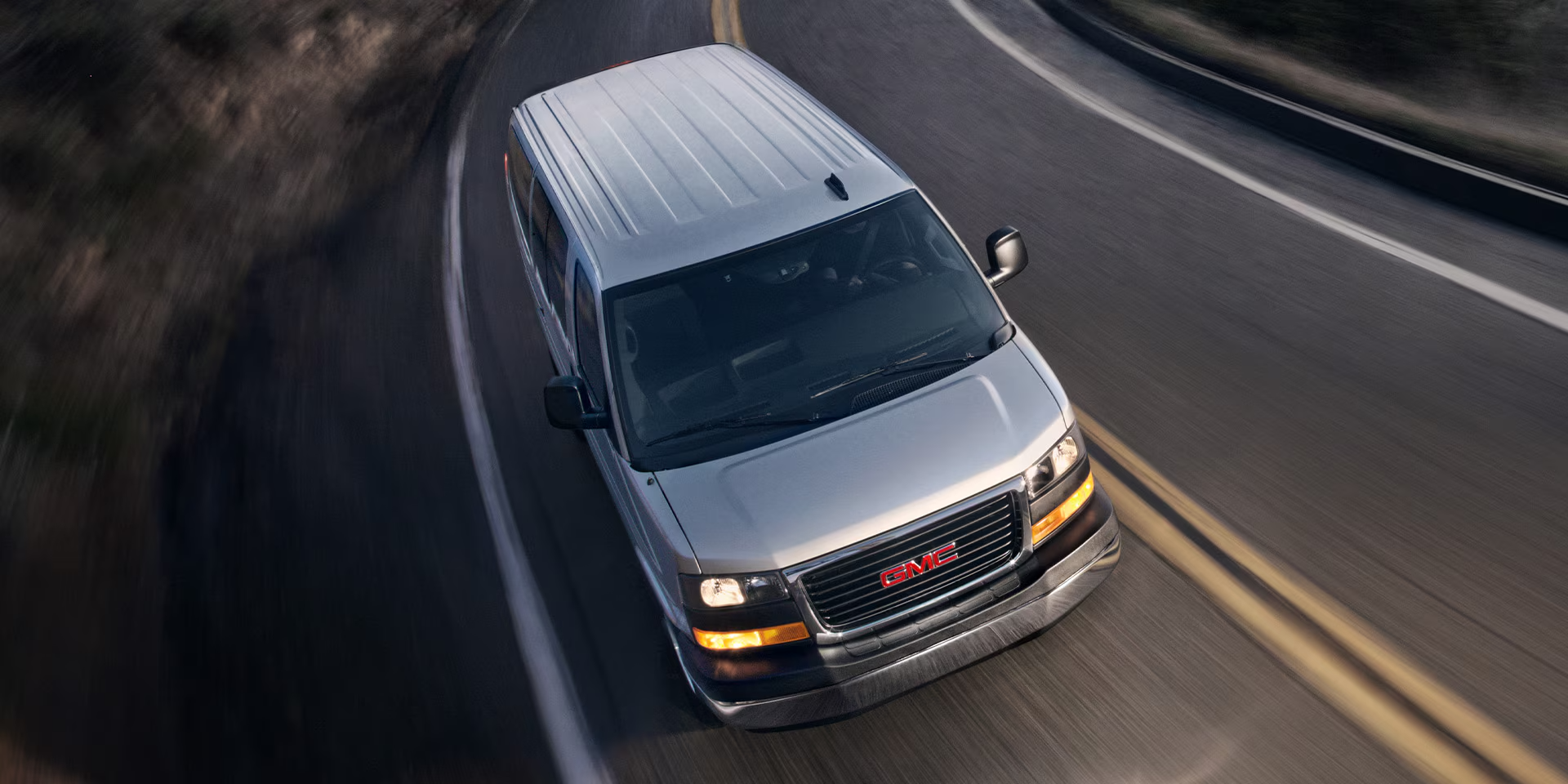 A 2024 GMC Savana Passenger Van driving